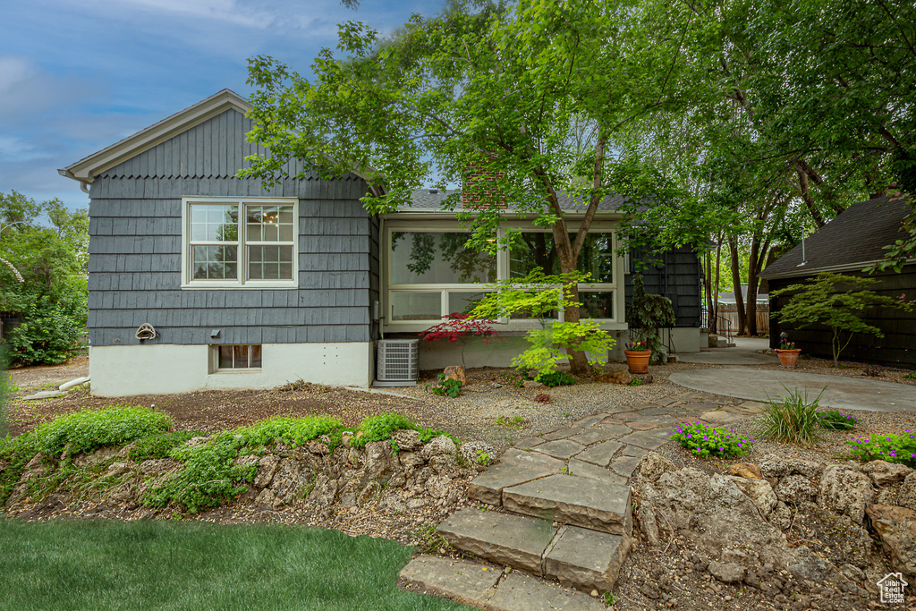 View of front of property with a patio and central AC