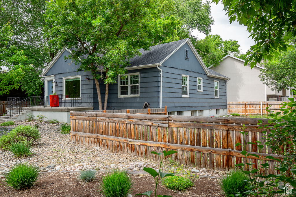Rear view of house featuring a shingled roof