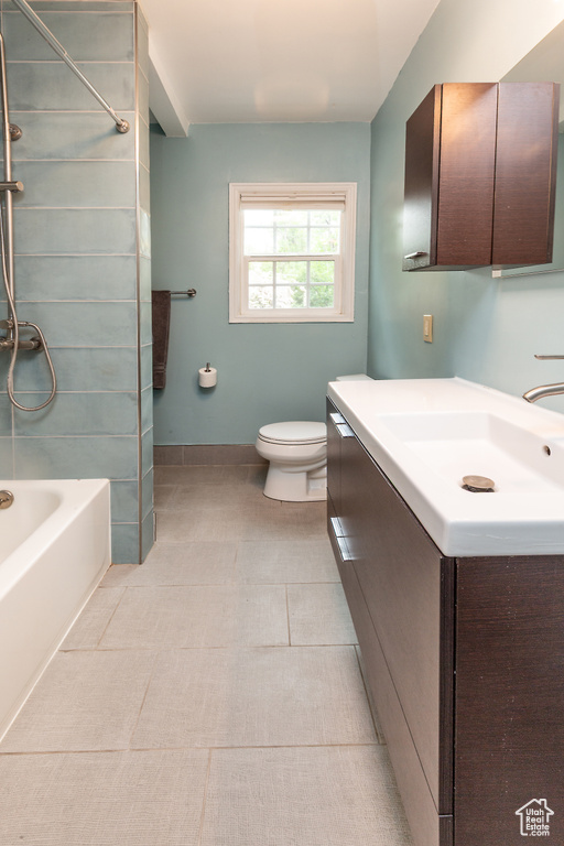 Full bathroom with toilet, vanity, shower / washtub combination, and baseboards