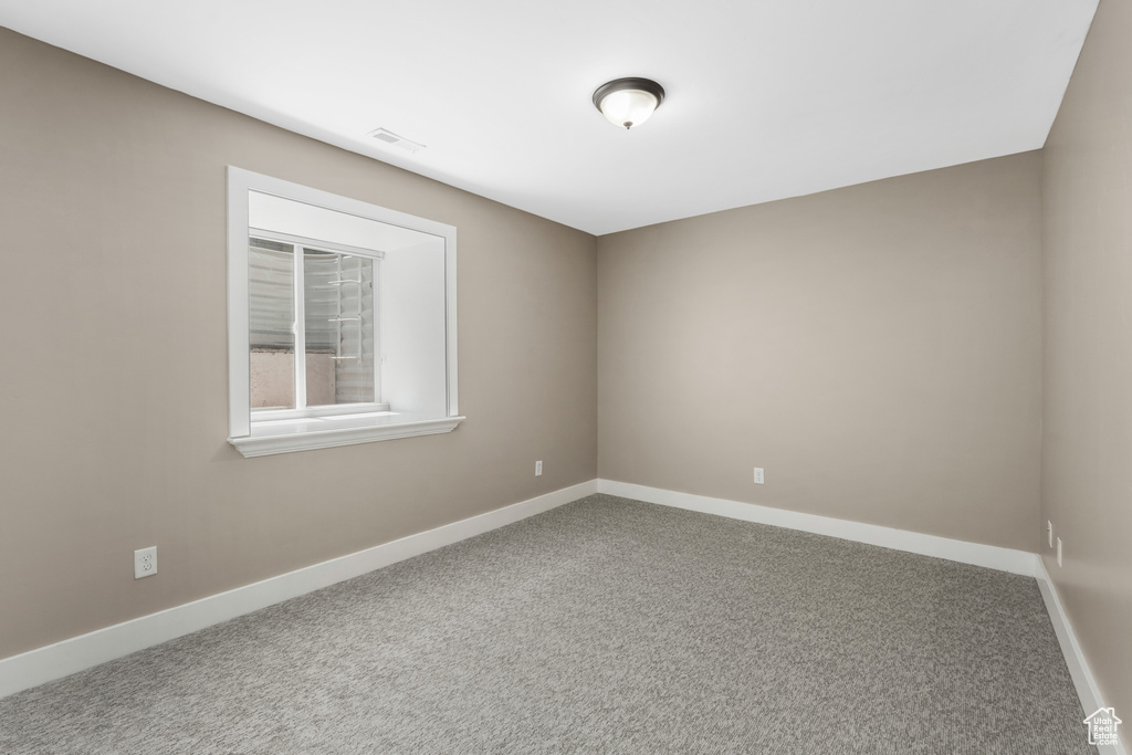 Empty room with carpet and baseboards