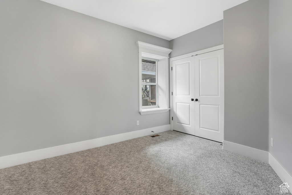 Unfurnished bedroom featuring carpet, baseboards, and a closet
