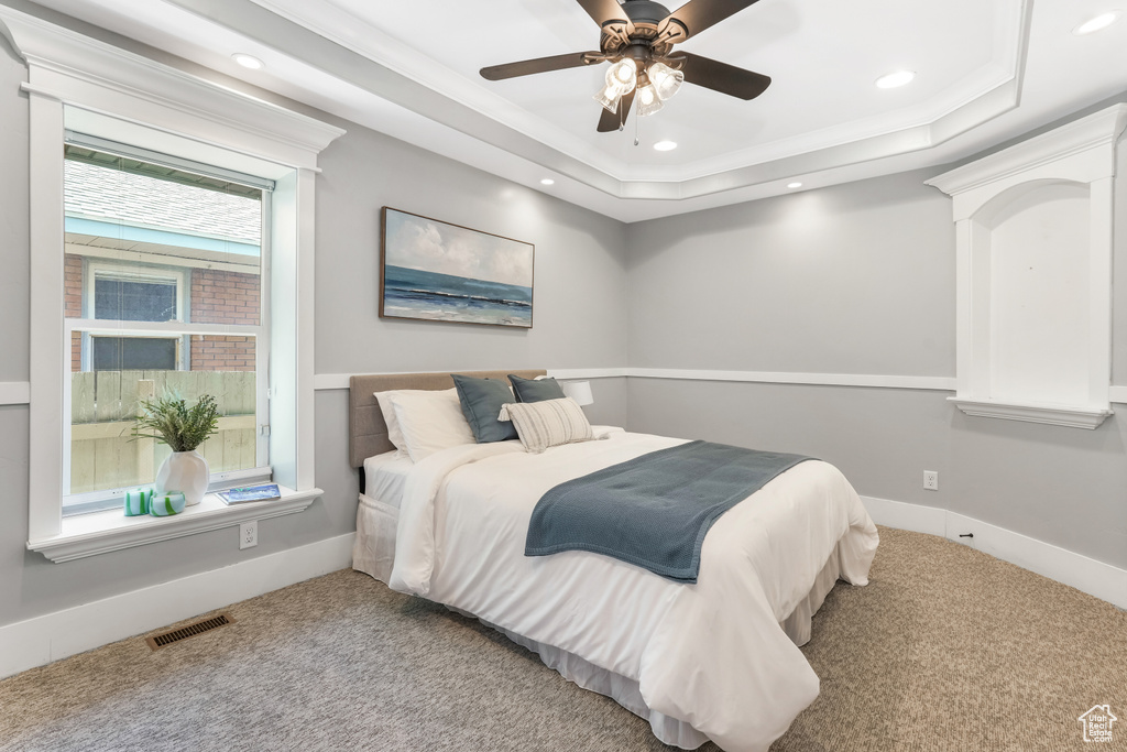 Bedroom with carpet floors, a raised ceiling, crown molding, recessed lighting, and baseboards