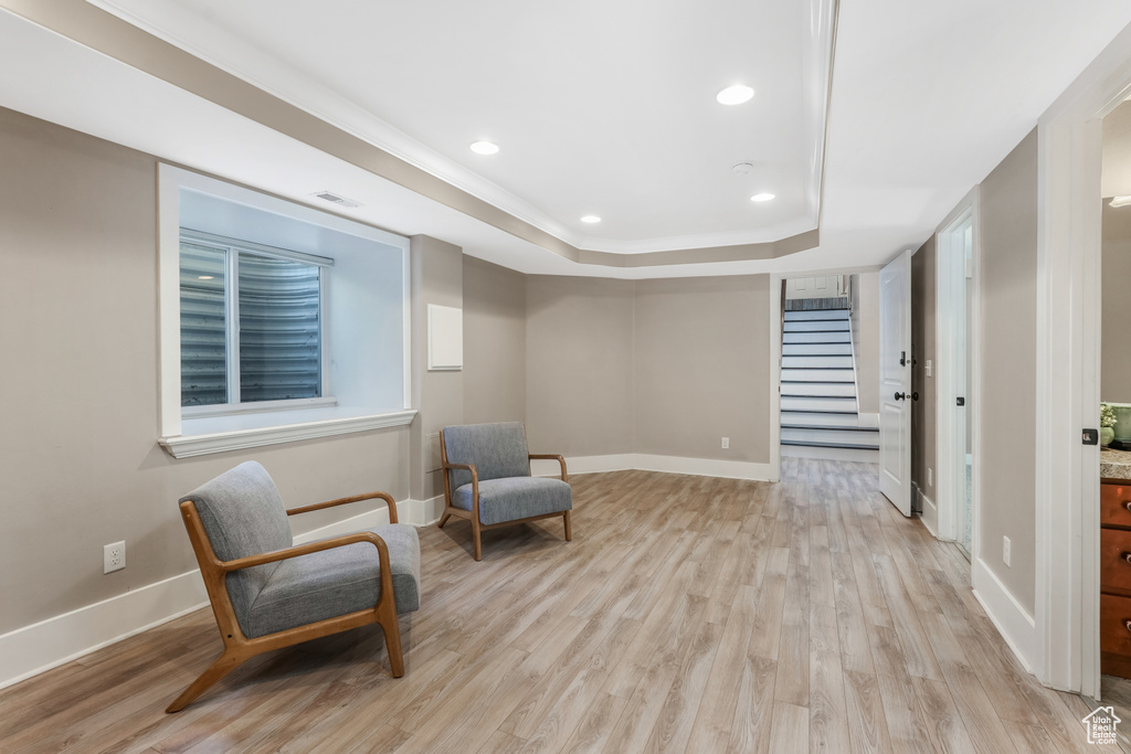 Unfurnished room featuring a raised ceiling, stairway, baseboards, light wood-style flooring, and recessed lighting