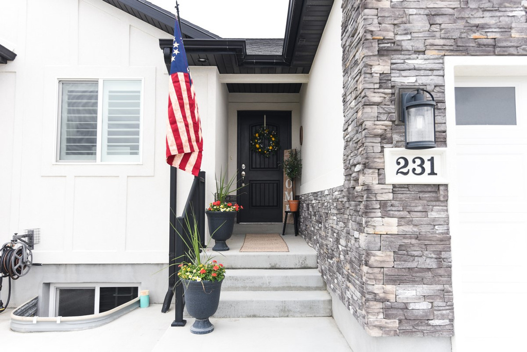 View of exterior entry featuring stone siding and stucco siding