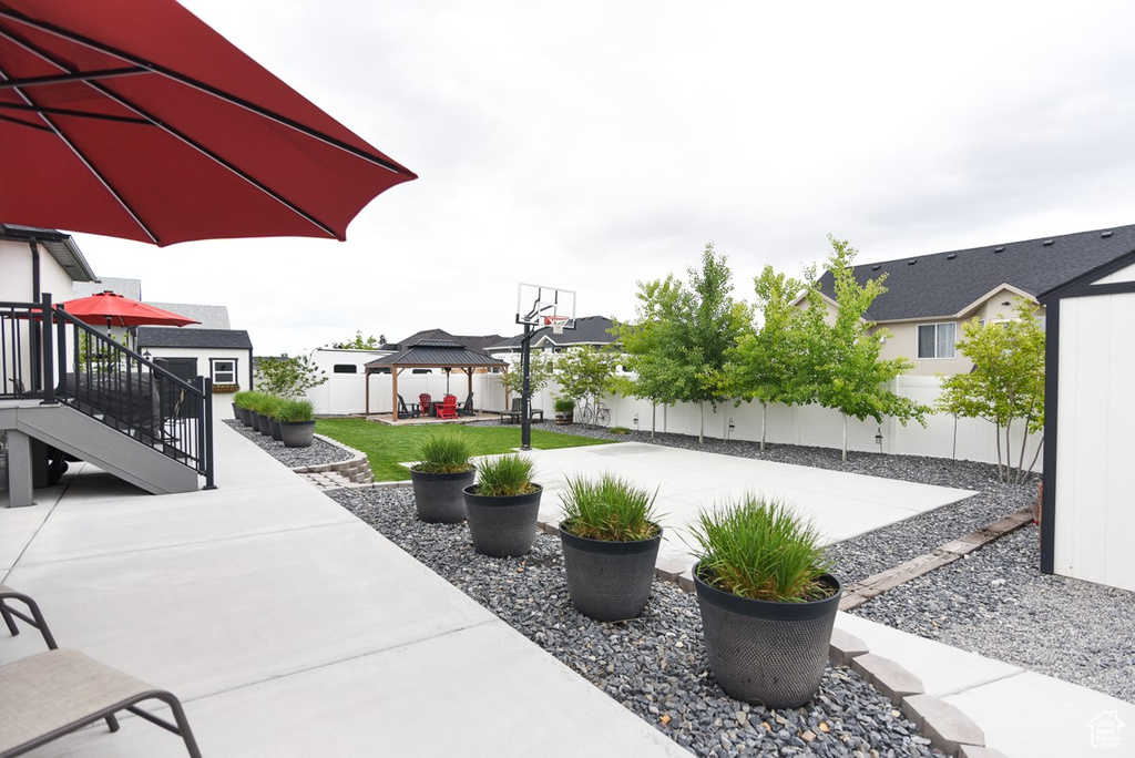 View of patio / terrace with a gazebo, a fenced backyard, and stairs