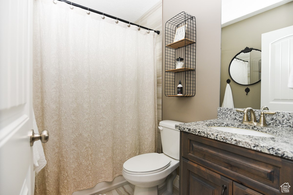 Full bath featuring toilet, vanity, and a shower with curtain