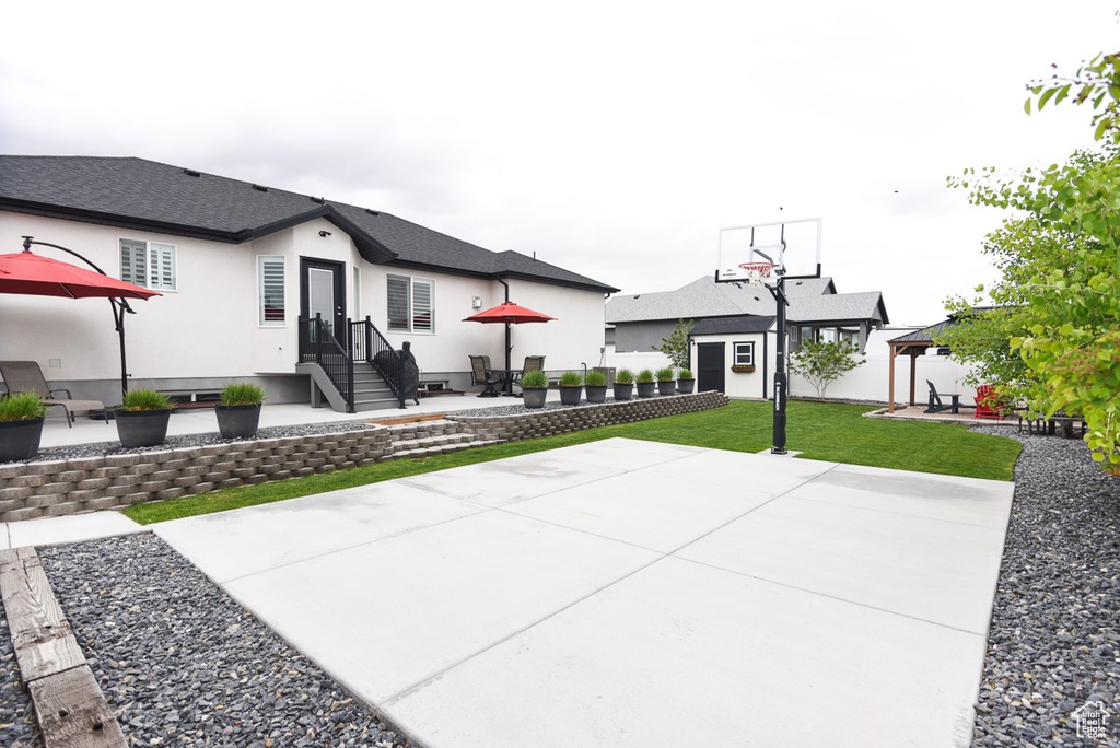 View of basketball court with a gazebo and a yard