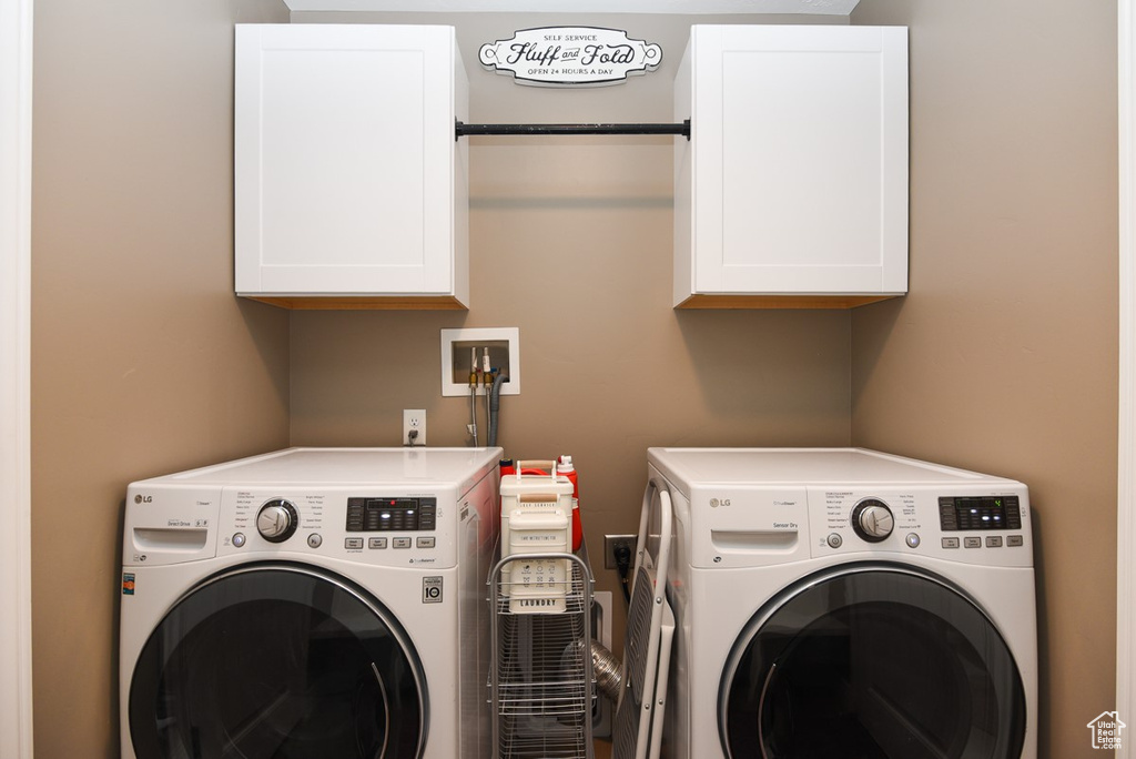 Washroom featuring cabinet space and independent washer and dryer