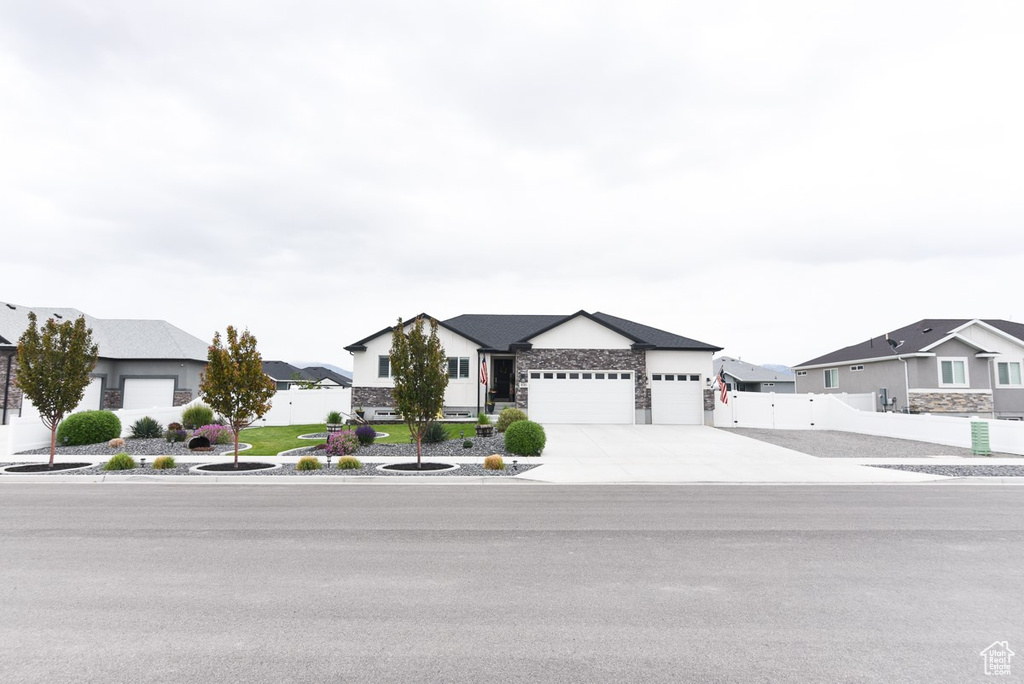 View of front of property with an attached garage, a residential view, and fence