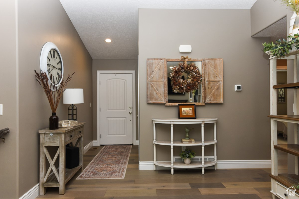 Foyer entrance with wood finished floors, recessed lighting, and baseboards