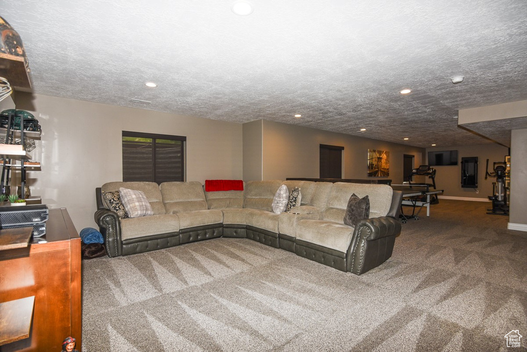 Carpeted living area with recessed lighting, a textured ceiling, and baseboards