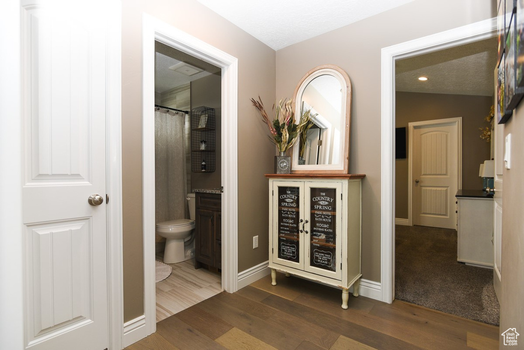 Corridor with dark wood finished floors, baseboards, and recessed lighting