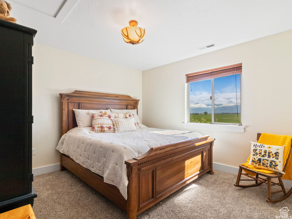 Bedroom featuring light carpet and baseboards