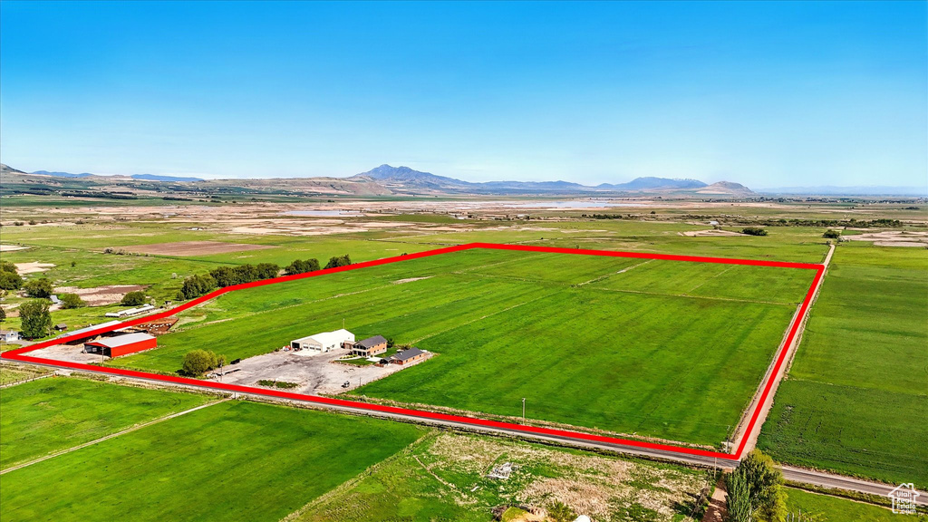Aerial view of sparsely populated area featuring property parcel outlined and a mountainous background