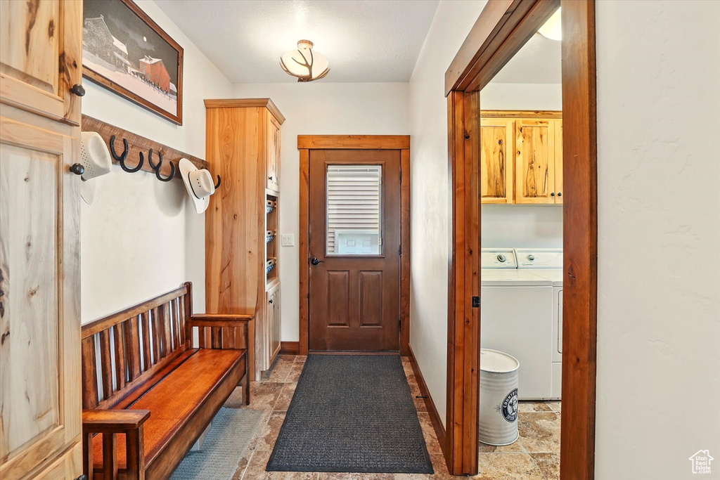 Mudroom featuring separate washer and dryer and light stone finish flooring