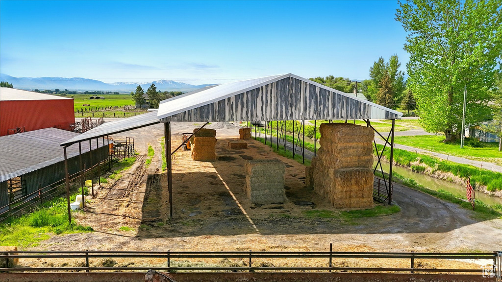 View of jungle gym with an exterior structure, a mountain view, an outbuilding, and a view of rural / pastoral area