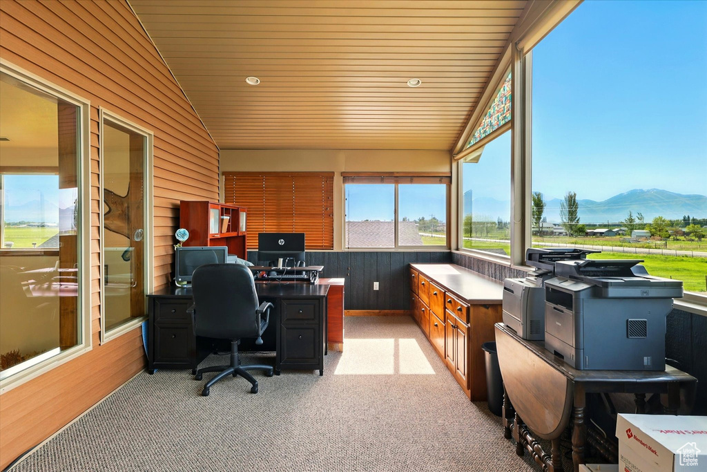 Office area featuring vaulted ceiling, light colored carpet, wooden walls, and wooden ceiling
