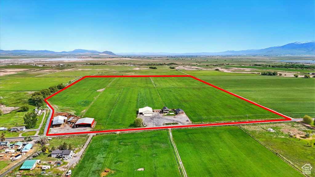 Aerial view of sparsely populated area featuring property boundaries highlighted and a mountainous background