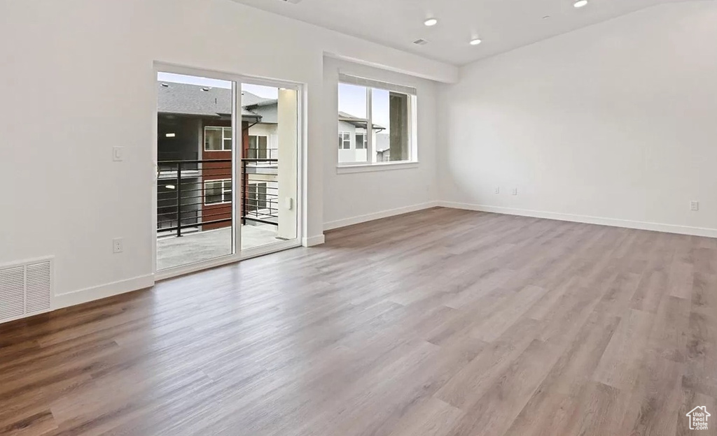 Unfurnished room featuring baseboards, wood finished floors, and visible vents