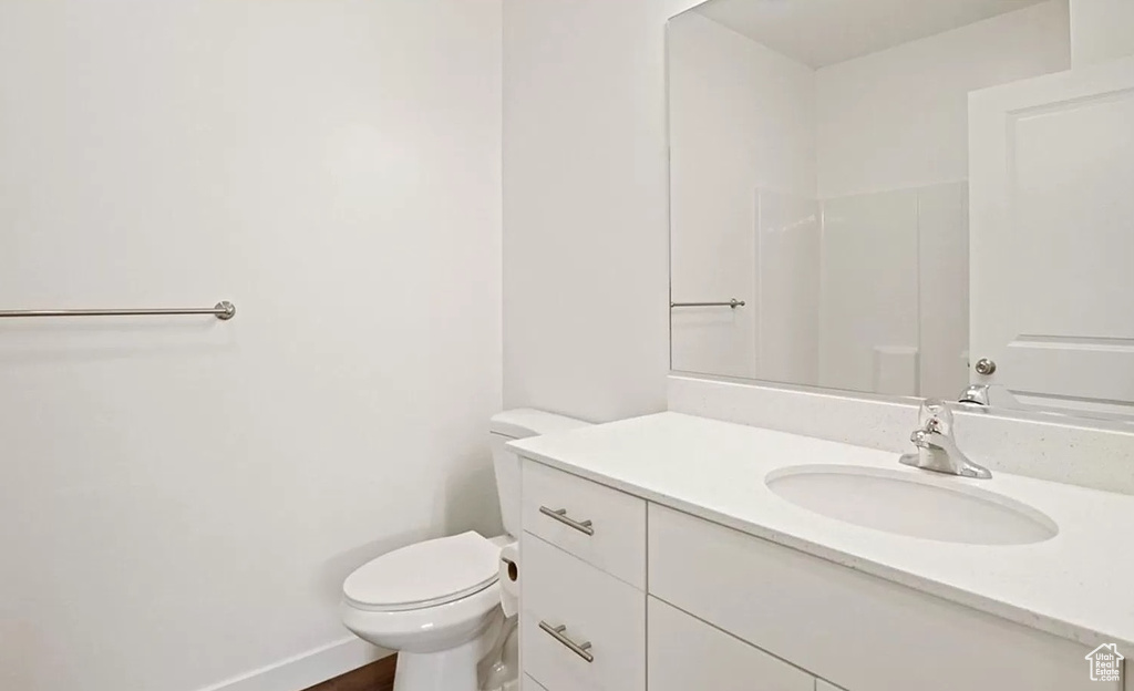 Bathroom with baseboards, toilet, and vanity