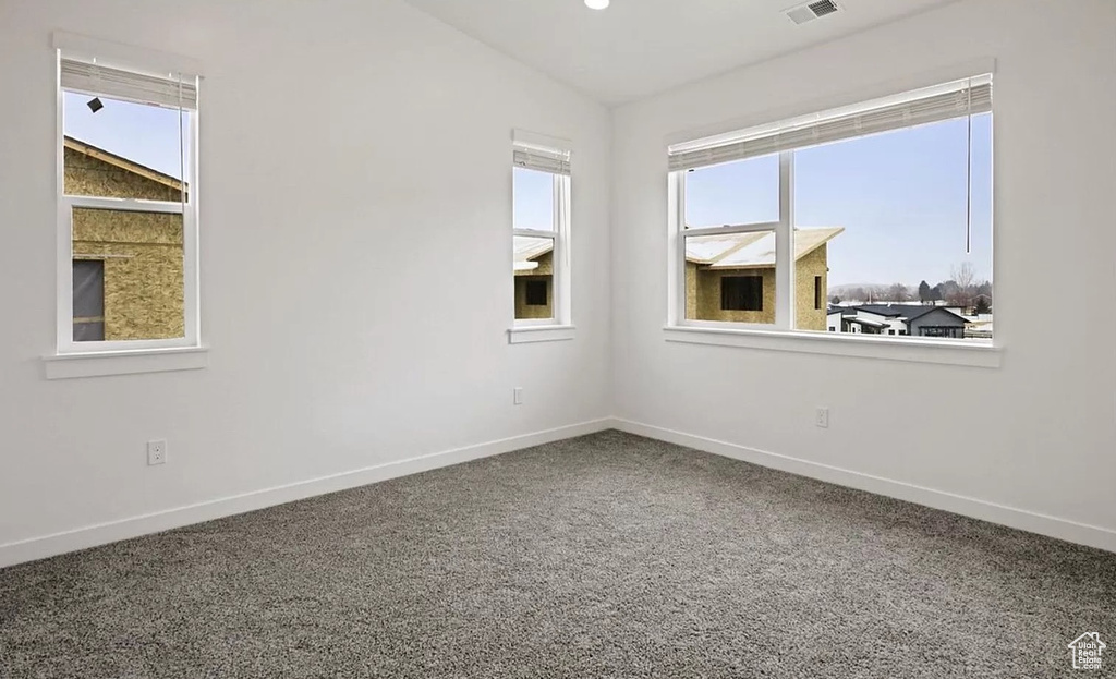 Empty room featuring a wealth of natural light and baseboards