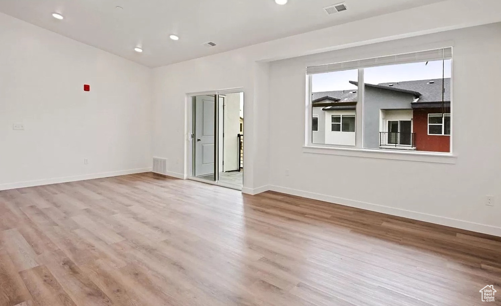 Spare room with baseboards, wood finished floors, and visible vents