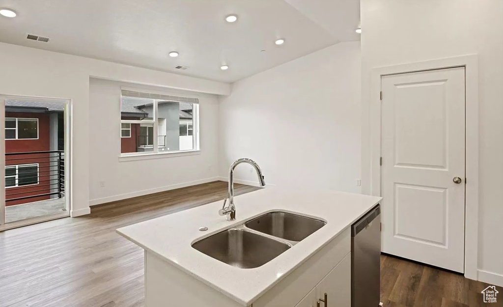 Kitchen featuring stainless steel dishwasher, dark wood-type flooring, a sink, and visible vents
