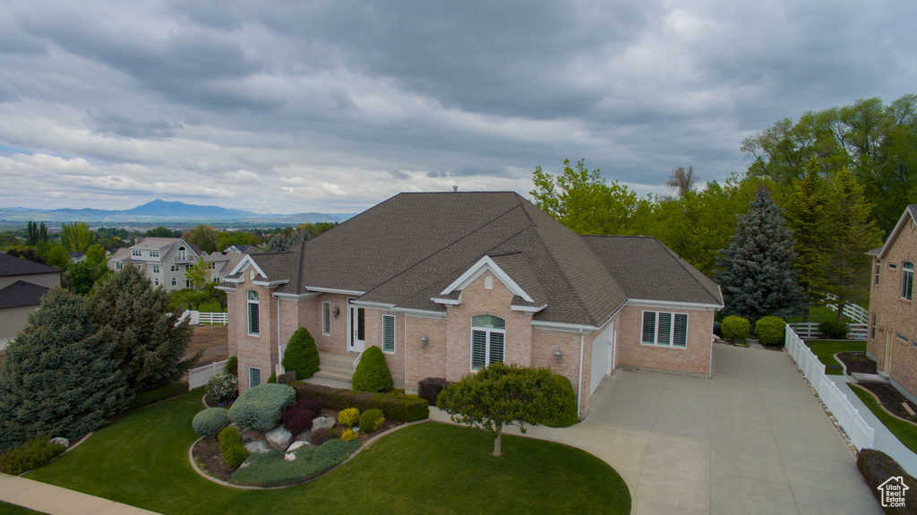 Traditional-style home with driveway, brick siding, a garage, and a mountain view