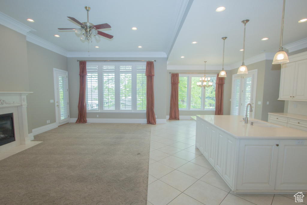 Kitchen with a sink, plenty of natural light, a high end fireplace, ceiling fan, and recessed lighting
