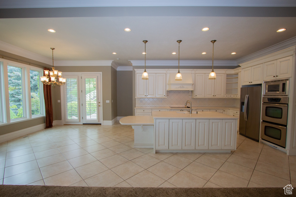 Kitchen featuring stainless steel appliances, light countertops, a chandelier, light tile patterned flooring, and recessed lighting