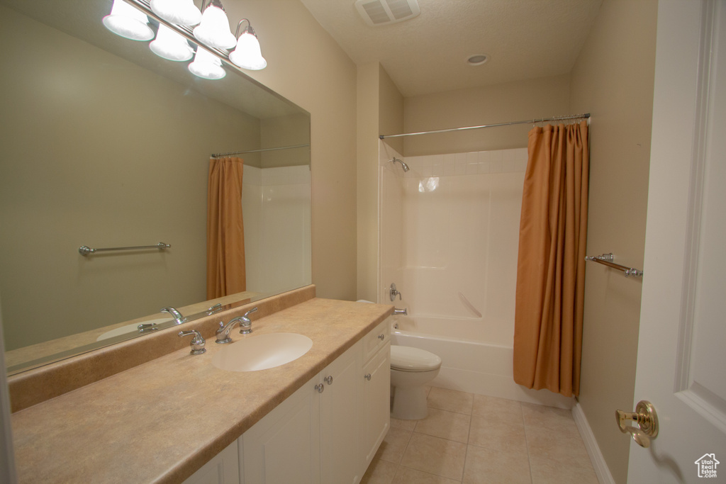 Bathroom with tile patterned flooring, vanity, shower / bath combination with curtain, and toilet
