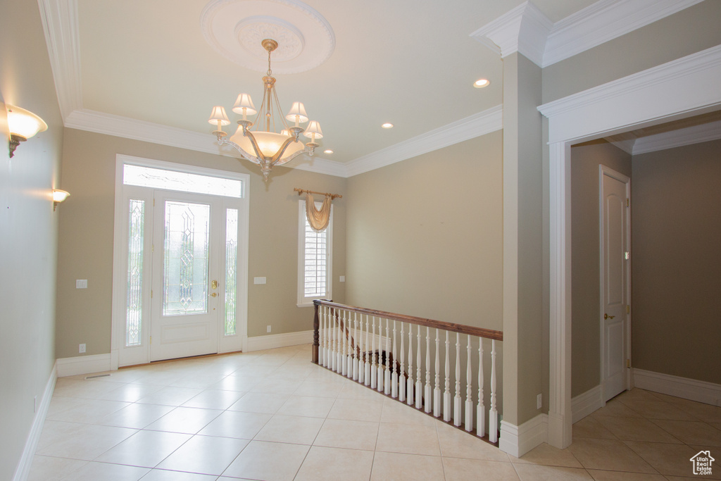 Entrance foyer featuring a chandelier, recessed lighting, crown molding, light tile patterned floors, and baseboards