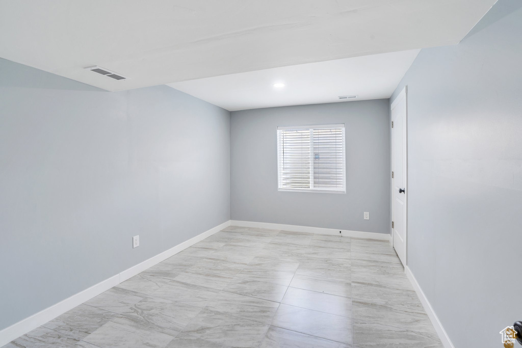 Empty room with light marble finish floors, baseboards, and recessed lighting