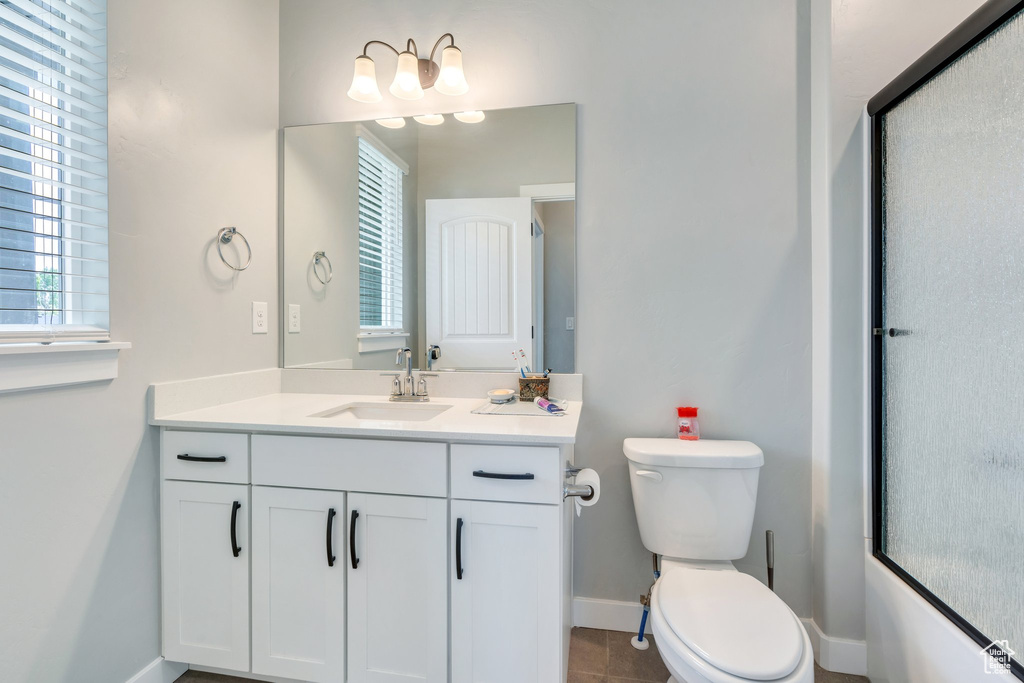 Bathroom with baseboards, vanity, and toilet