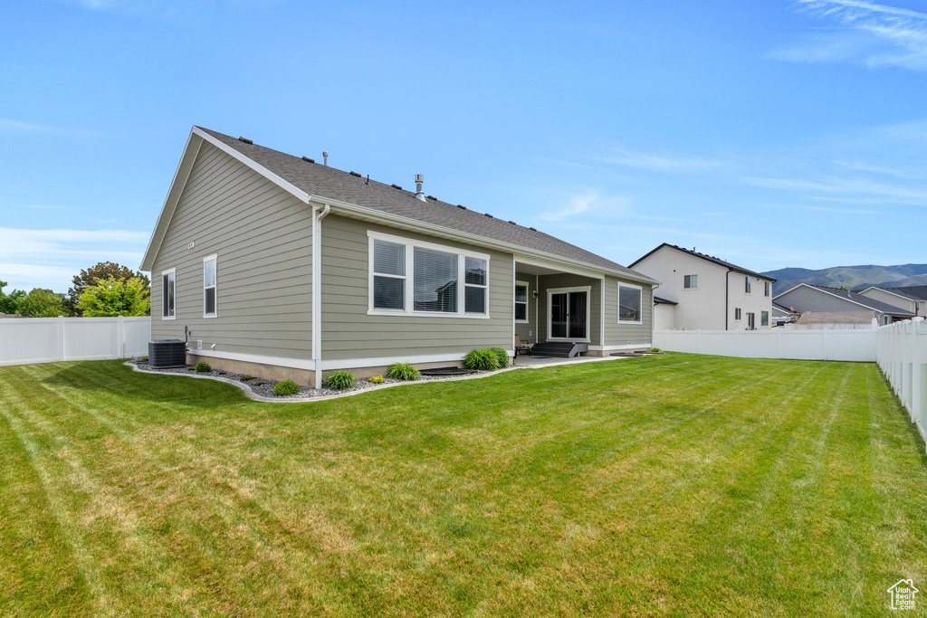 Back of house with cooling unit and a patio area