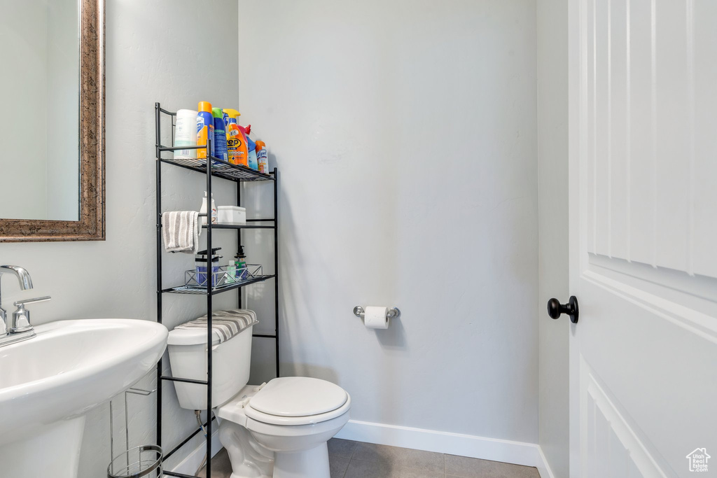Bathroom with a sink, baseboards, toilet, and tile patterned floors