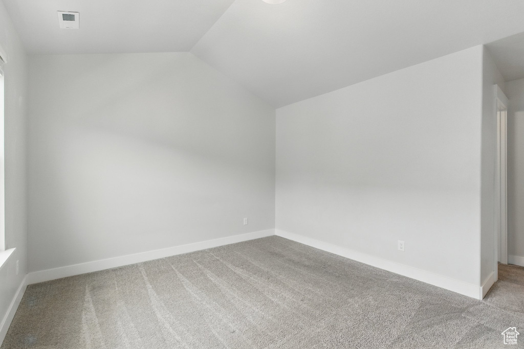 Bonus room with carpet flooring, lofted ceiling, and baseboards