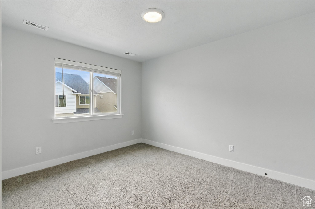 Carpeted spare room with baseboards