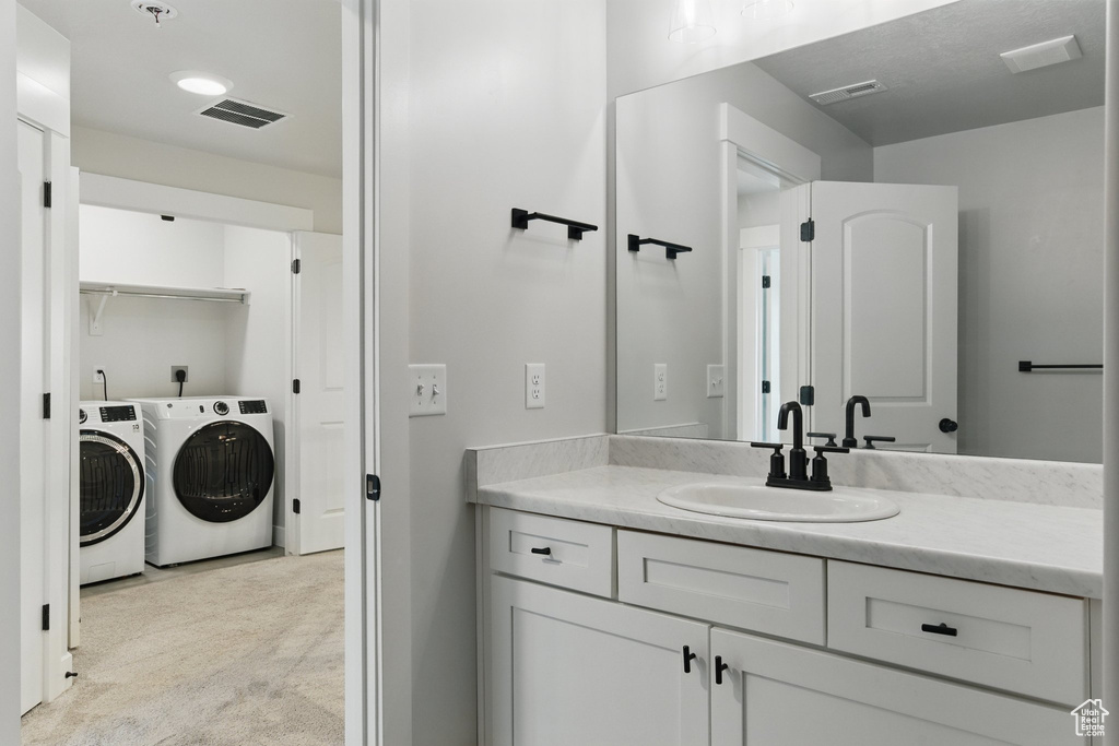 Bathroom featuring washer and dryer and vanity