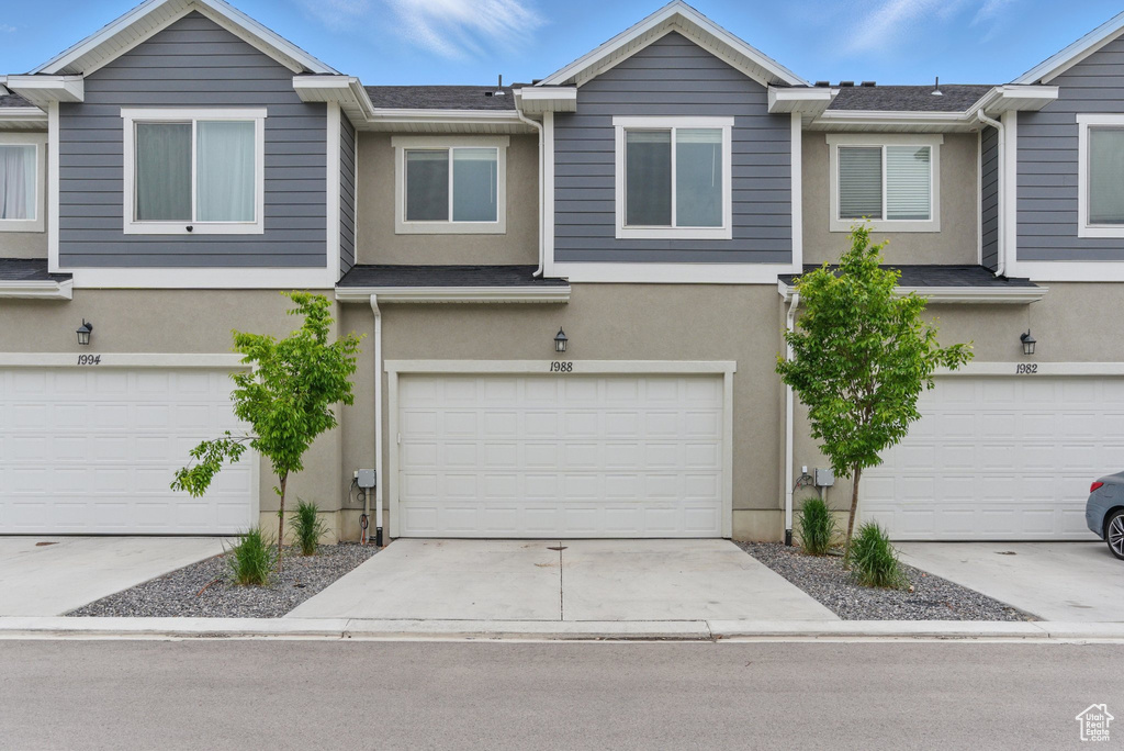 Multi unit property featuring stucco siding, an attached garage, and concrete driveway