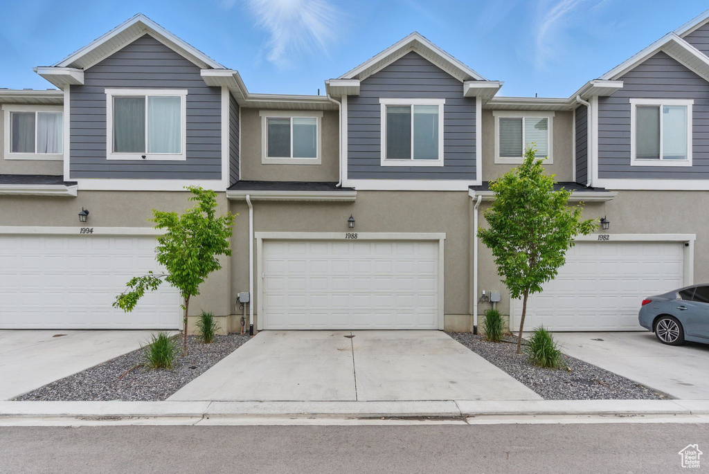Multi unit property with an attached garage, stucco siding, and driveway