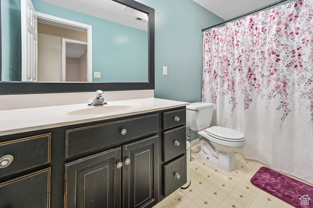Full bathroom featuring vanity, toilet, and a shower with curtain