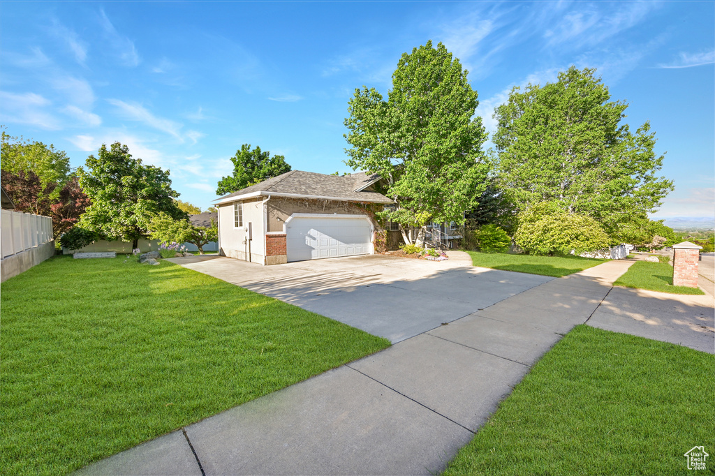 Obstructed view of property with brick siding, roof with shingles, and driveway