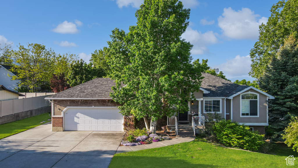 View of front of home featuring brick siding, a shingled roof, driveway, and an attached garage