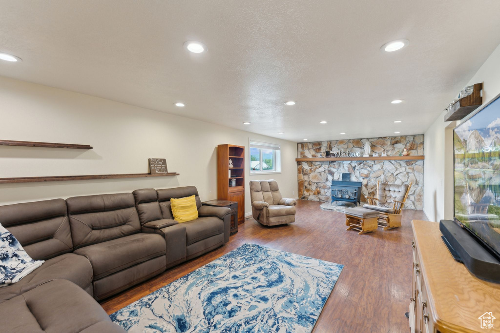 Living room featuring a wood stove, wood finished floors, and recessed lighting