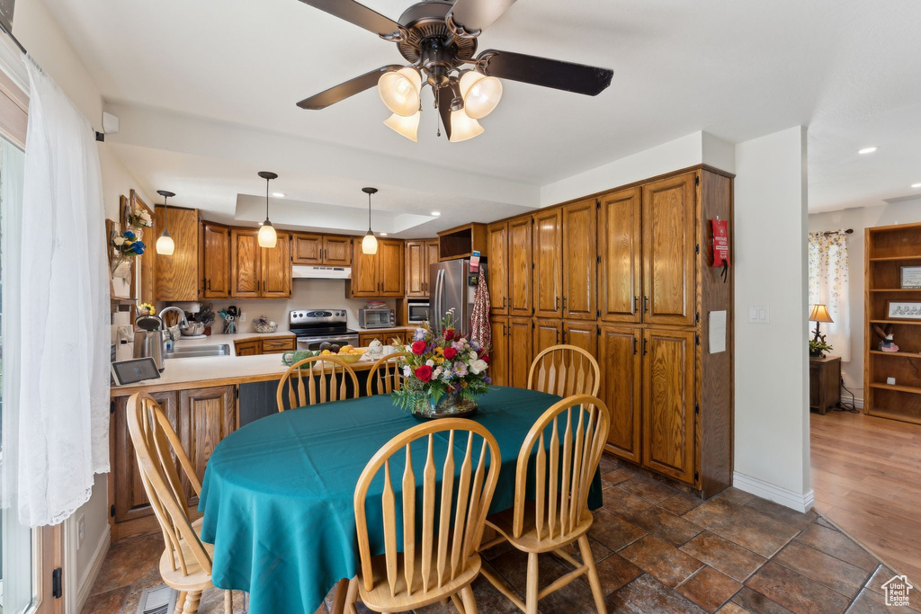 Dining space featuring ceiling fan, recessed lighting, baseboards, and dark stone finish flooring