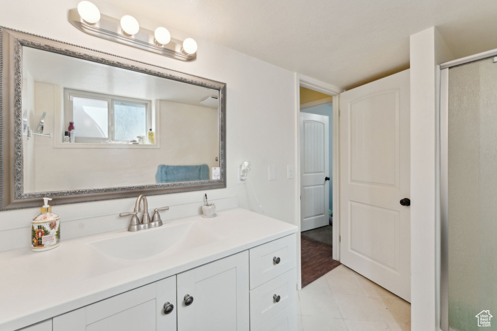 Bathroom featuring vanity, tile patterned flooring, and an enclosed shower