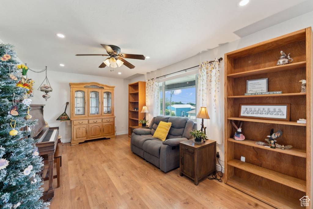 Living area with a ceiling fan, light wood finished floors, recessed lighting, and baseboards