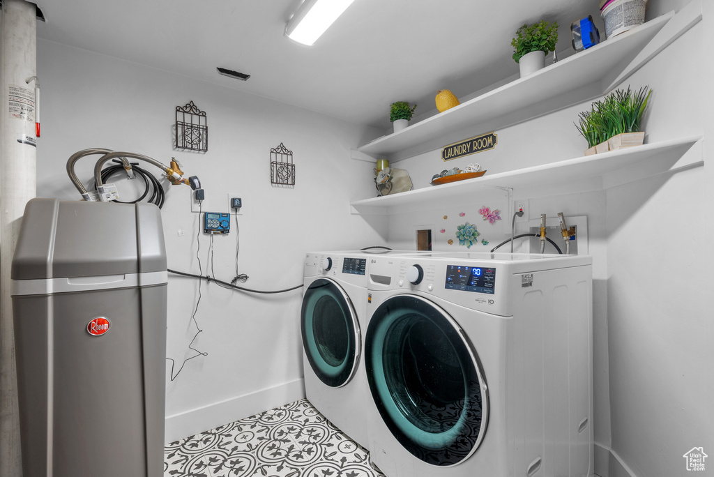 Laundry room featuring separate washer and dryer, tile patterned floors, and baseboards