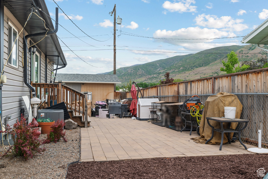 View of patio with a mountain view and a fenced backyard